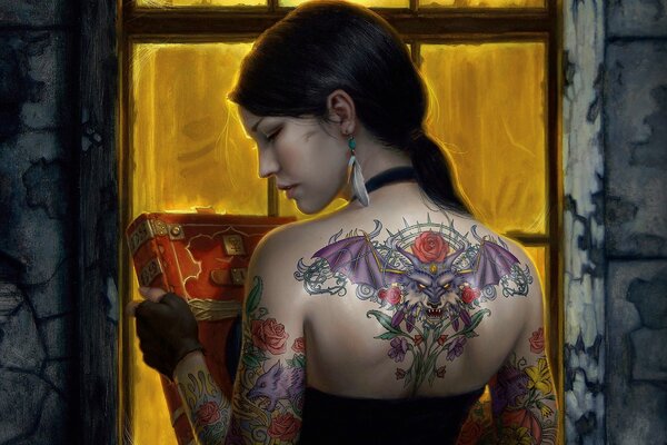 Fille avec un tatouage sur le dos et un livre dans les mains