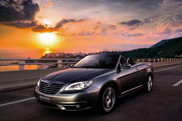 Belle voiture sur fond de coucher de soleil