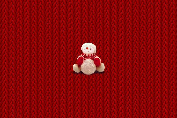 Bonhomme de neige en peluche sur fond tressé rouge