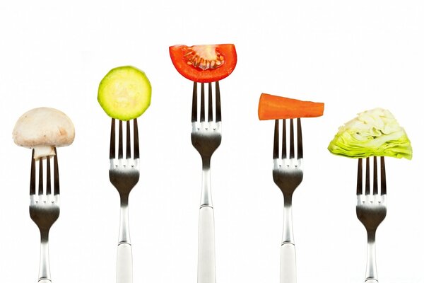 Légumes sur une fourchette sur un fond blanc