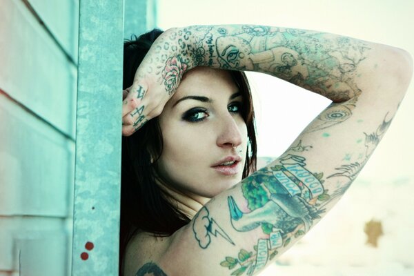 Fille avec des tatouages posant magnifiquement