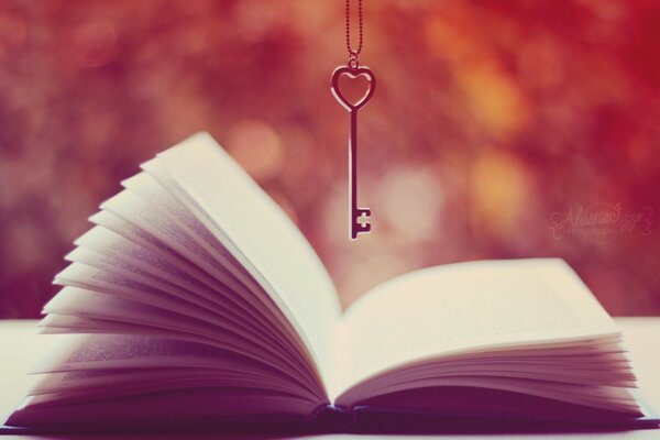 Image d un livre ouvert avec une clé suspendue au-dessus du livre