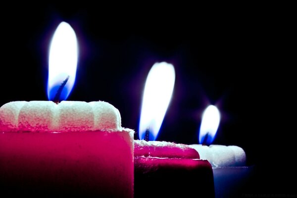 Flamme de bougies multicolores sur fond sombre