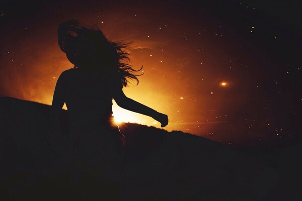 Silhouette sombre de la jeune fille au coucher du soleil
