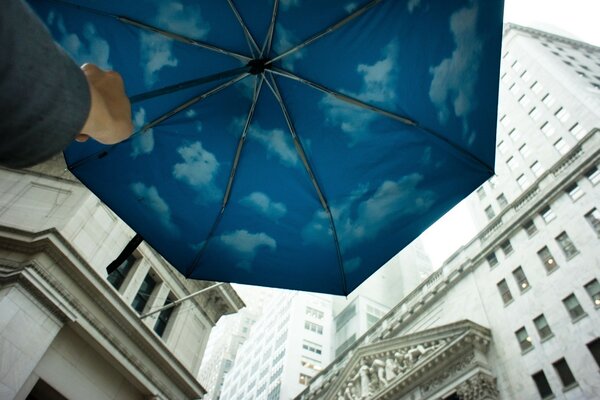 Parapluie bleu avec des nuages près de grandes maisons