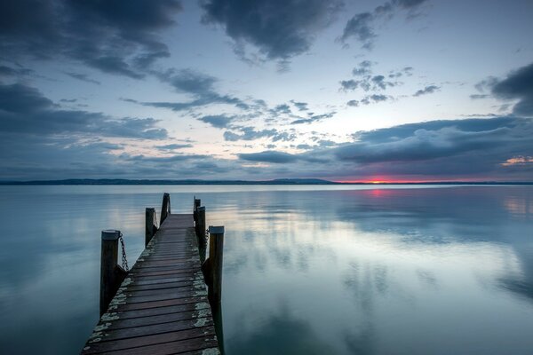 Dans le lac au coucher du soleil va une passerelle étroite