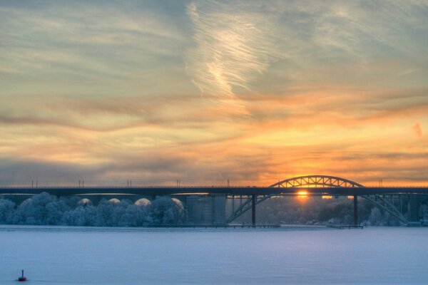 Poste ferroviaire sur fond de coucher de soleil. Paysage hivernal
